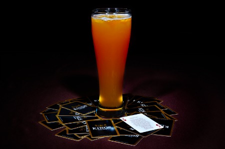 A glass full of beer placed over the king cards