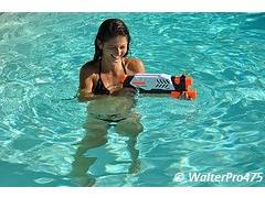 Girl playing with water-gun in a pool