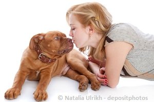 Young girl kissing a dog