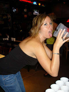 A beautiful girl drinking a large glass of beer