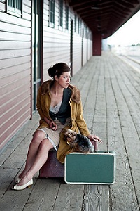 Lady with a green suitcase and a little puppy 
