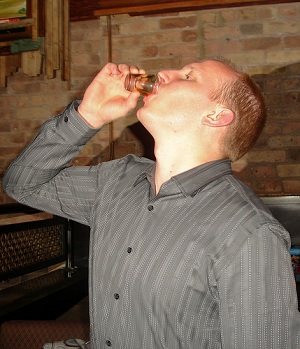 Man drinking a shot of alcohol while playing the Never Have I Ever game