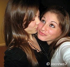 beautiful girl kissing on the cheek of other girl