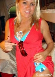 blonde girl pointing out an id card between her breasts